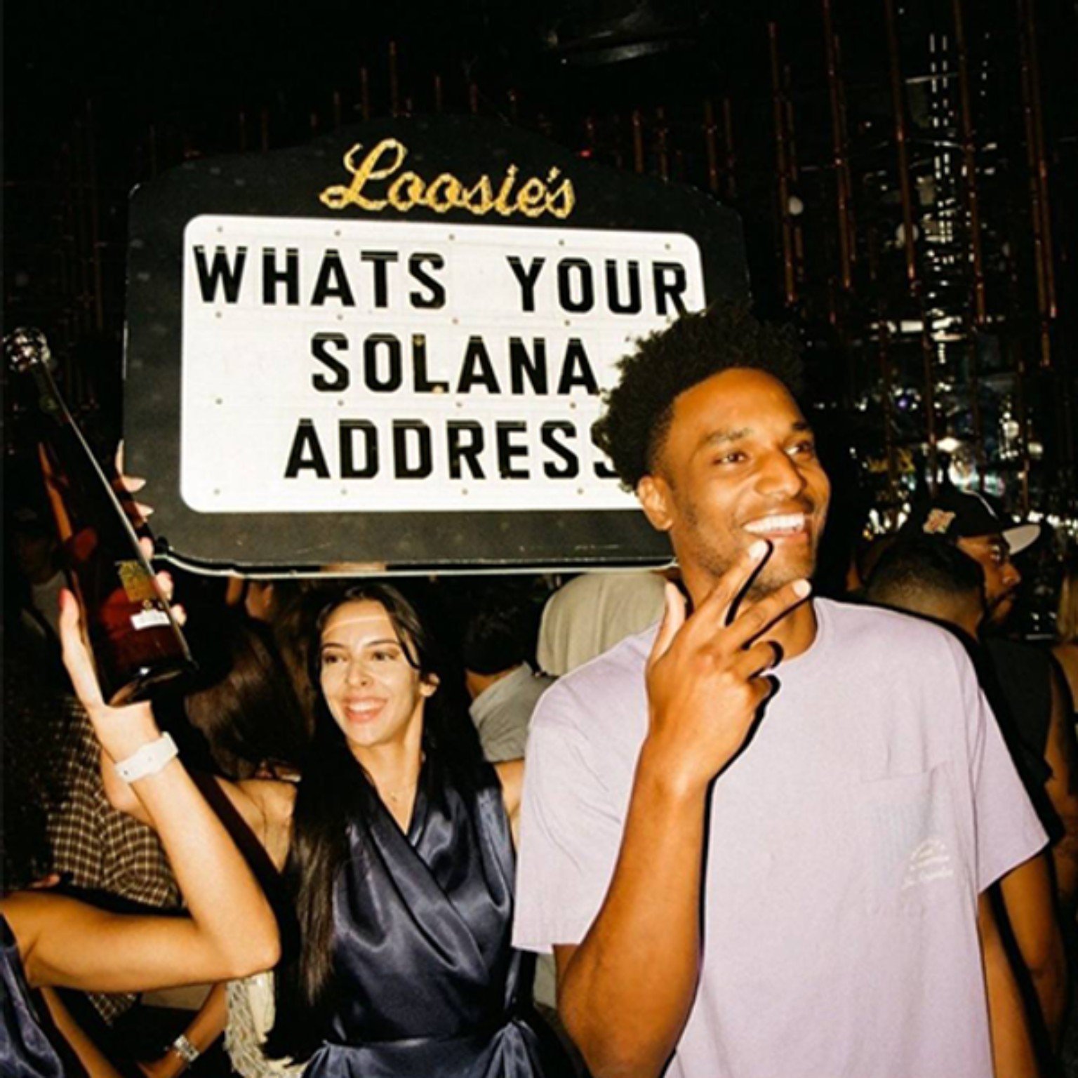 Official token image: Loosies event photograph with Solana address sign